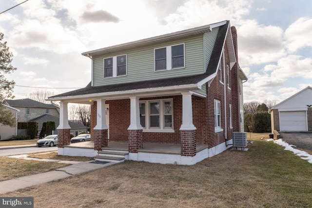 view of front of property with a porch, a front lawn, an outbuilding, a garage, and cooling unit