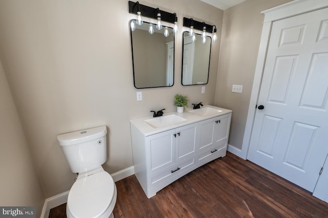 bathroom with toilet, wood-type flooring, and vanity