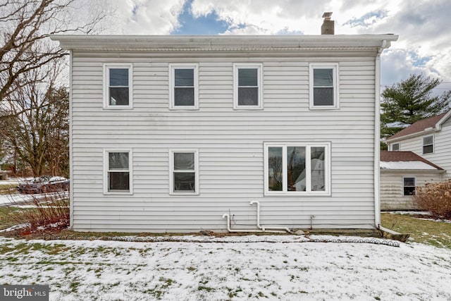 view of snow covered rear of property