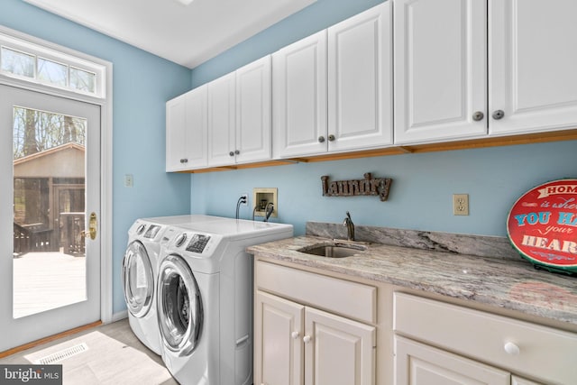 laundry area featuring independent washer and dryer, visible vents, a sink, and cabinet space