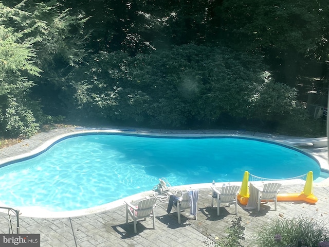 outdoor pool with a patio area