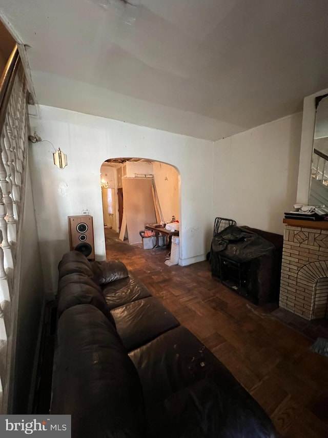 living room featuring parquet floors and a stone fireplace