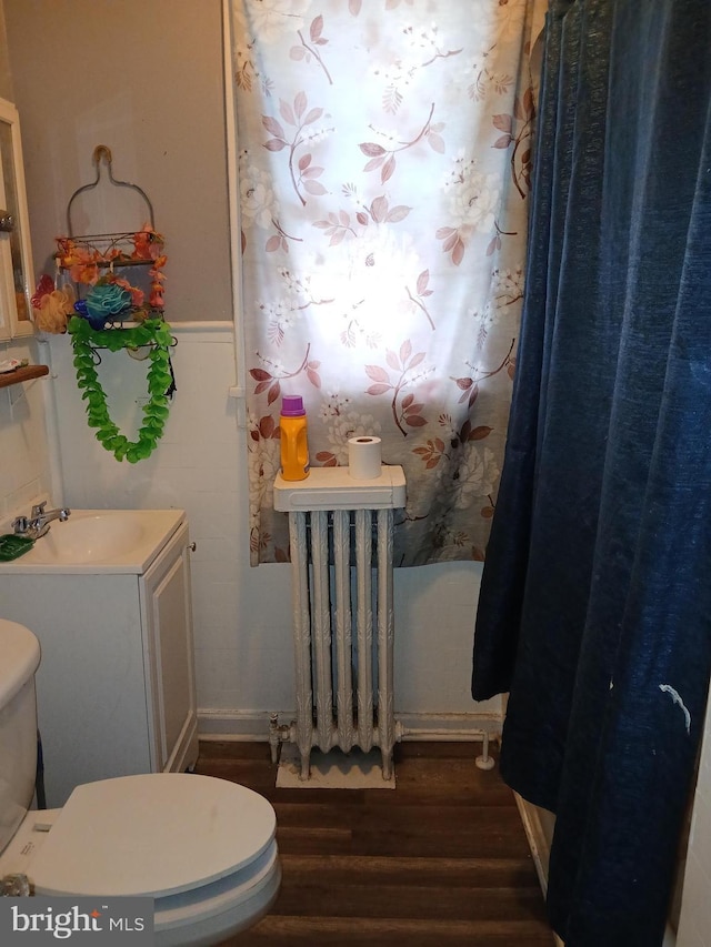 bathroom featuring sink, hardwood / wood-style floors, radiator, and toilet