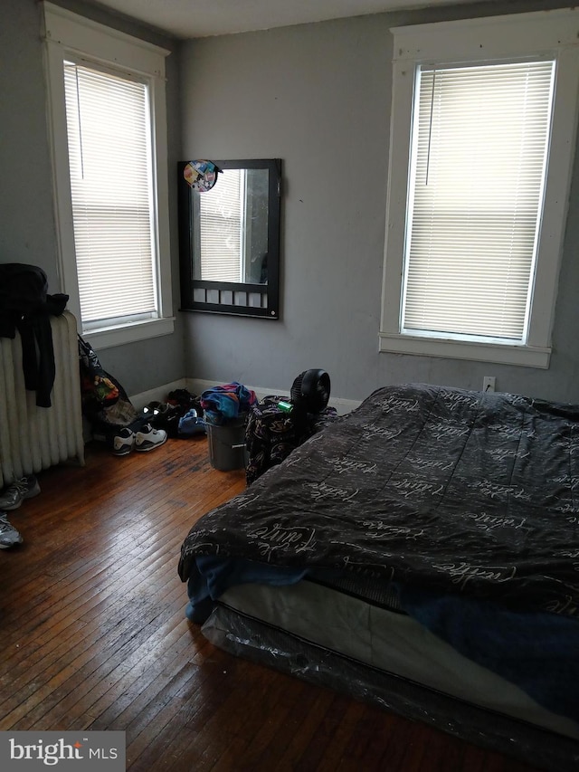 bedroom with hardwood / wood-style flooring and radiator