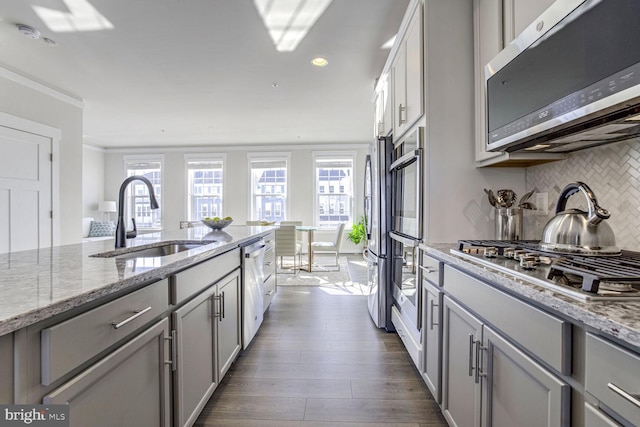 kitchen with plenty of natural light, appliances with stainless steel finishes, gray cabinetry, and sink