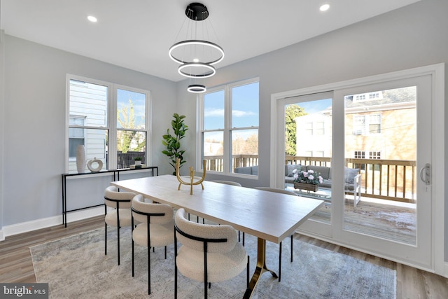 dining area featuring a wealth of natural light, a chandelier, and wood-type flooring