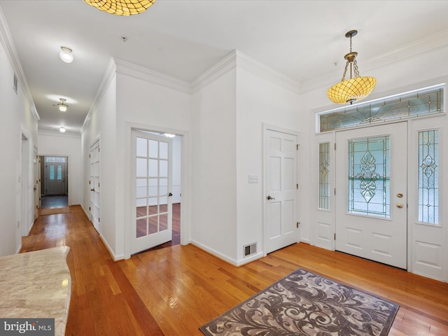 foyer entrance featuring crown molding and hardwood / wood-style flooring