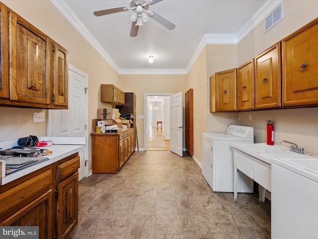 kitchen with ceiling fan, ornamental molding, and washing machine and clothes dryer