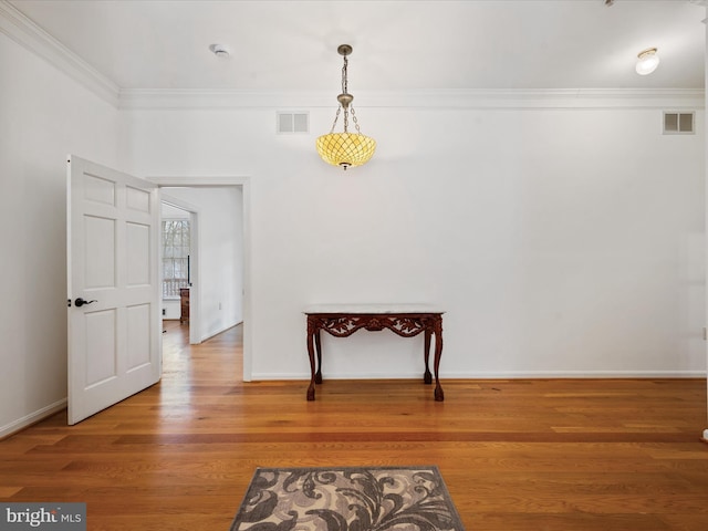 unfurnished room with ornamental molding and hardwood / wood-style flooring