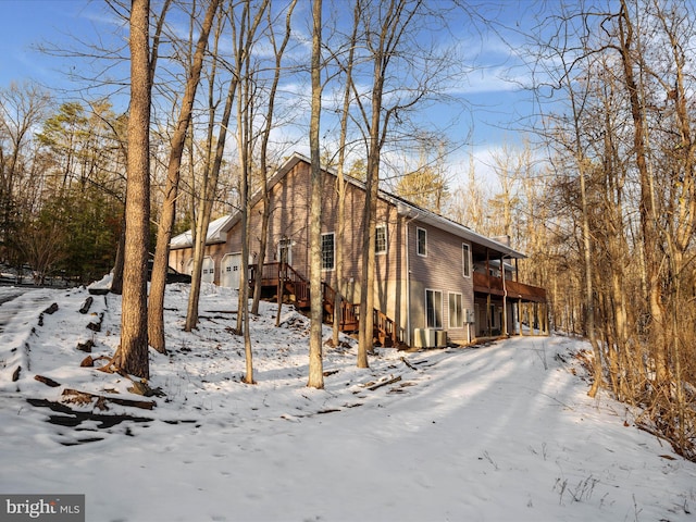 exterior space featuring cooling unit, a wooden deck, and a garage