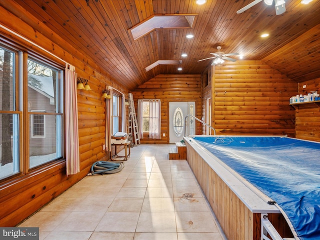 interior space featuring ceiling fan, wooden ceiling, lofted ceiling with skylight, and log walls