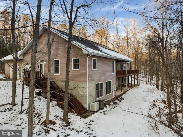 view of snowy exterior featuring central AC unit