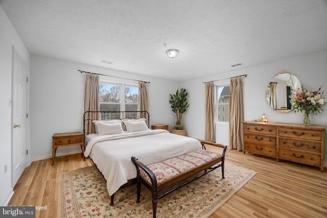 bedroom featuring a textured ceiling and light wood-type flooring