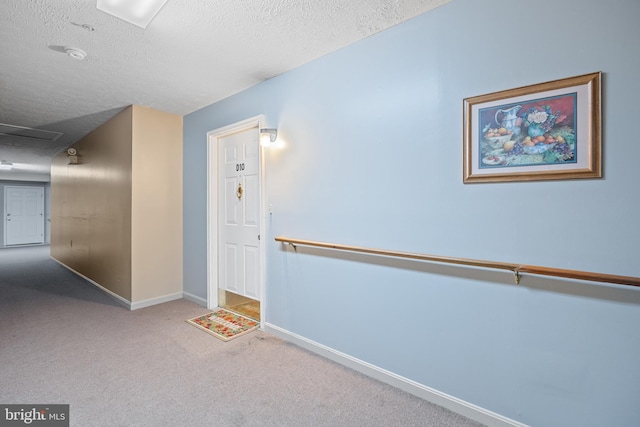 hallway featuring carpet floors and a textured ceiling