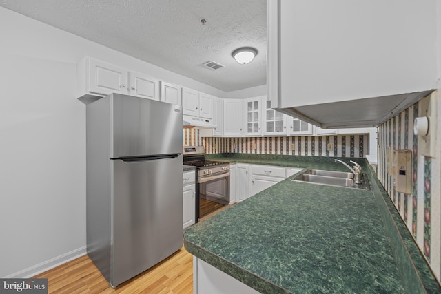 kitchen featuring sink, stainless steel appliances, light hardwood / wood-style floors, and white cabinets