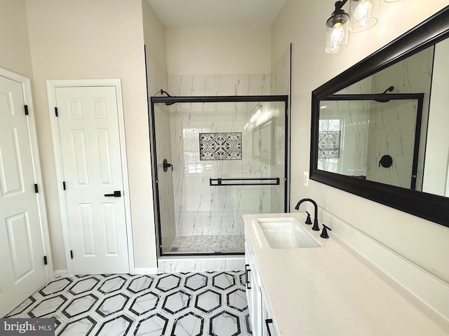 bathroom featuring a shower with shower door and vanity