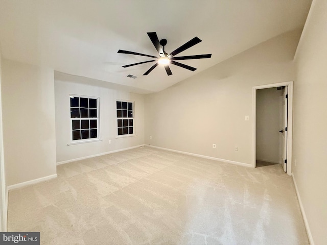 carpeted spare room featuring vaulted ceiling and ceiling fan