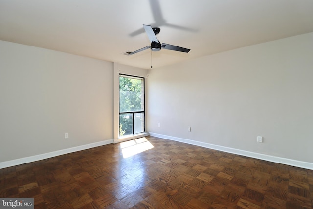 unfurnished room with ceiling fan and dark parquet floors