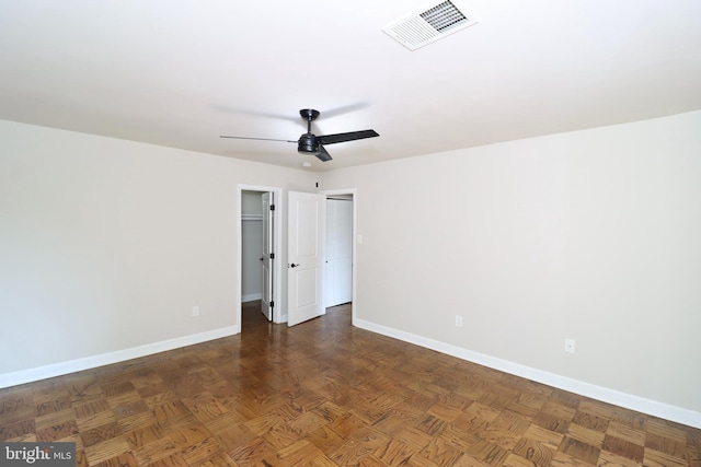 spare room featuring ceiling fan and dark parquet floors