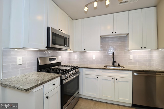 kitchen featuring appliances with stainless steel finishes, white cabinets, and sink