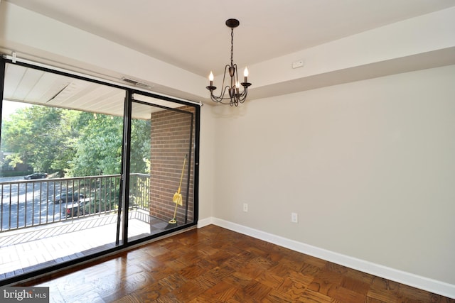 spare room with an inviting chandelier and dark parquet floors