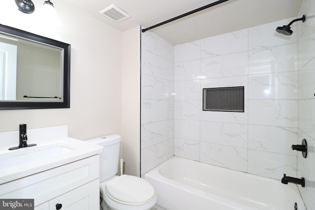 full bathroom featuring vanity, tiled shower / bath combo, and toilet