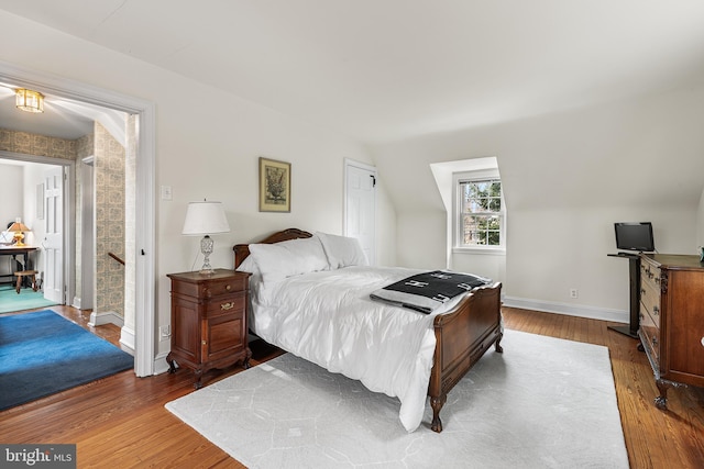 bedroom with lofted ceiling and wood-type flooring