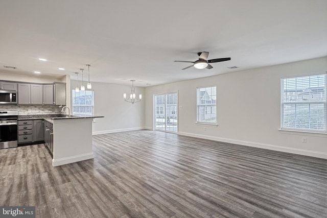 kitchen featuring pendant lighting, stainless steel appliances, tasteful backsplash, sink, and gray cabinets