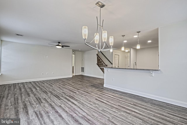 unfurnished living room featuring dark hardwood / wood-style floors, sink, and ceiling fan with notable chandelier