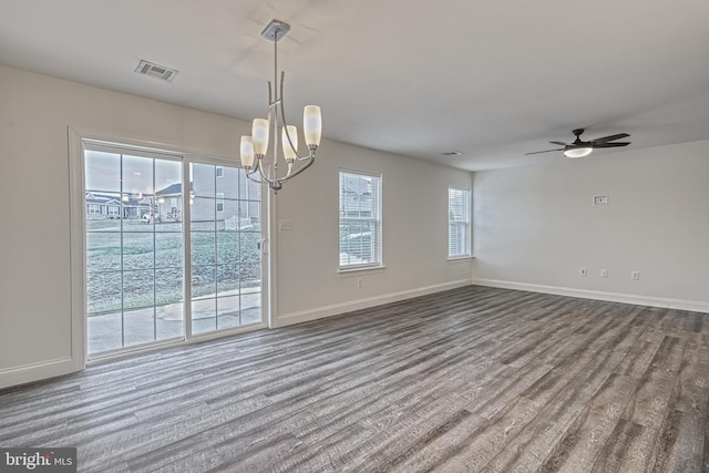 empty room featuring ceiling fan with notable chandelier and hardwood / wood-style floors