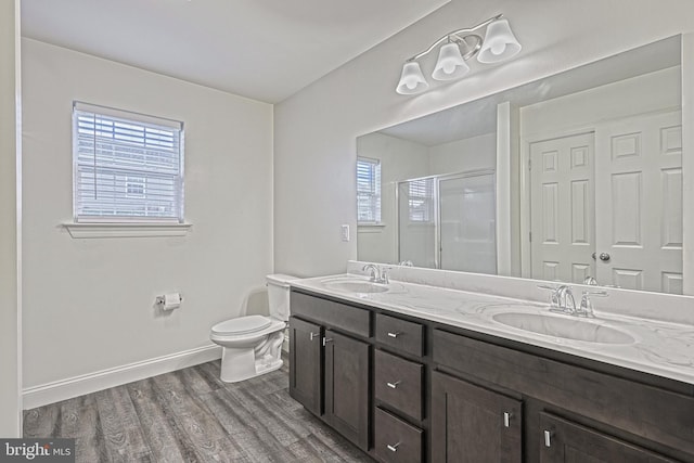 bathroom with vanity, toilet, hardwood / wood-style floors, and an enclosed shower