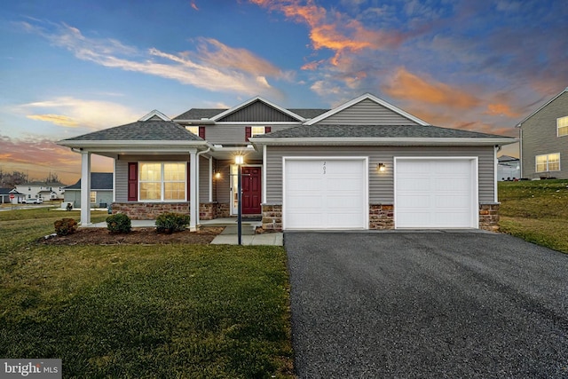 view of front of home with a garage and a lawn