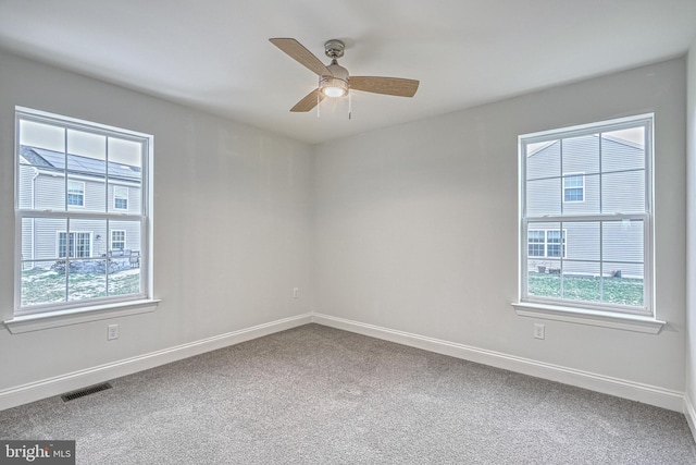 spare room featuring ceiling fan, a healthy amount of sunlight, and carpet floors