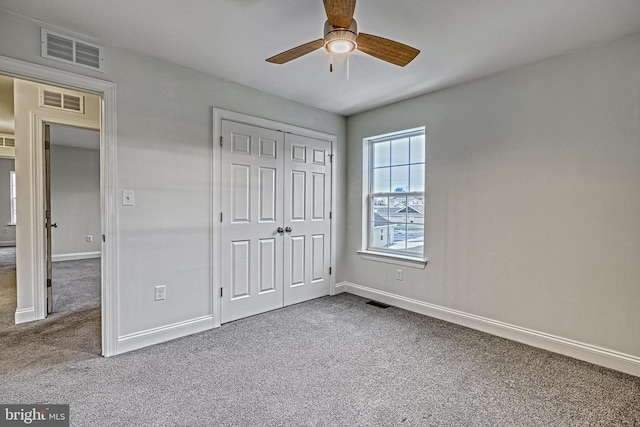 unfurnished bedroom with ceiling fan, carpet flooring, and a closet