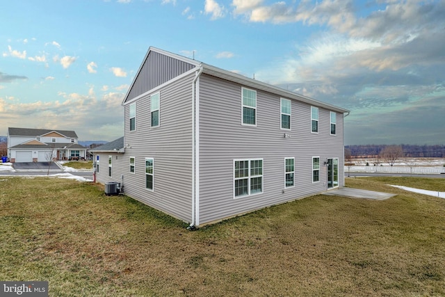 view of side of property with a yard and central AC unit