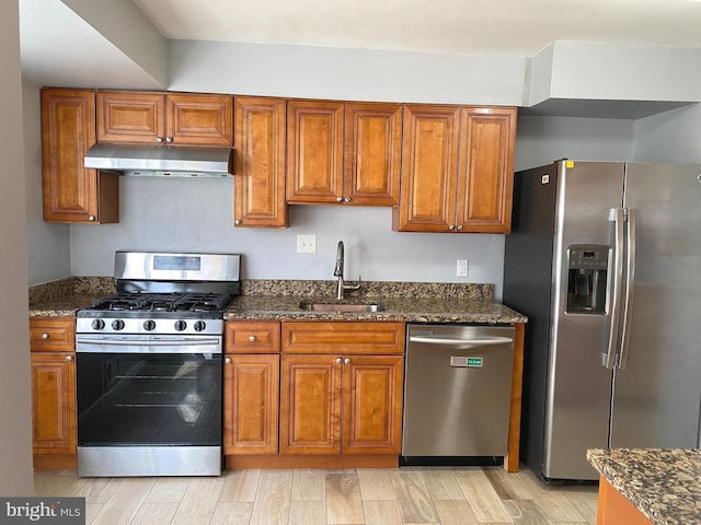 kitchen with sink, stainless steel appliances, and dark stone countertops