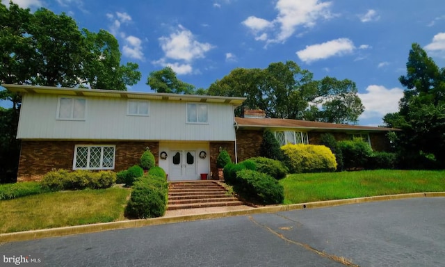 split level home featuring a front lawn