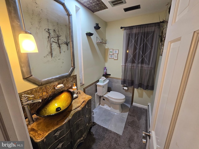 bathroom with vanity, a baseboard heating unit, tile patterned floors, and toilet