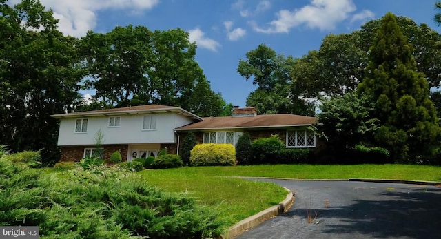 split level home featuring a front lawn