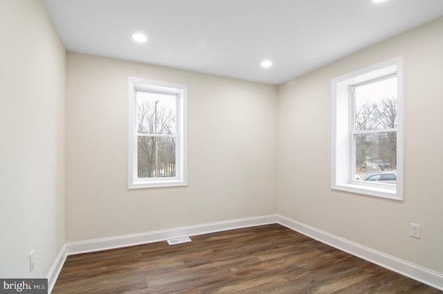 unfurnished room featuring dark hardwood / wood-style flooring and a wealth of natural light