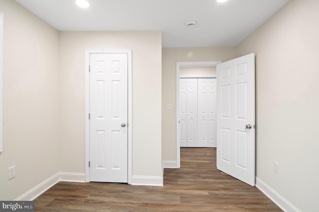 unfurnished bedroom with dark hardwood / wood-style flooring