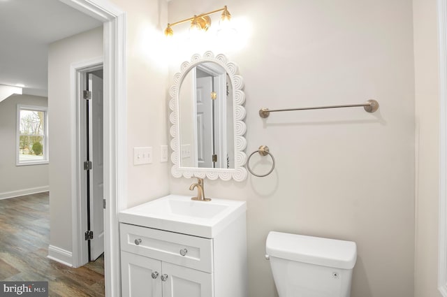 bathroom with vanity, toilet, and hardwood / wood-style floors