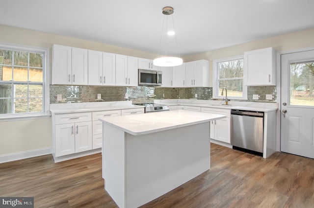 kitchen featuring pendant lighting, white cabinetry, a center island, and appliances with stainless steel finishes