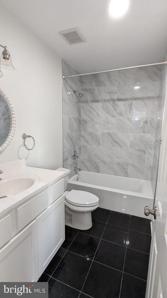 full bathroom featuring tiled shower / bath, vanity, toilet, and tile patterned floors