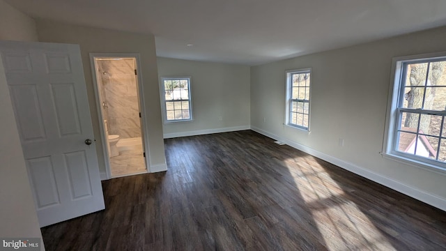 unfurnished room with a wealth of natural light and dark hardwood / wood-style floors