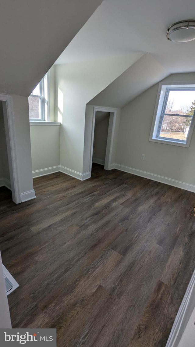 bonus room with lofted ceiling and dark hardwood / wood-style flooring