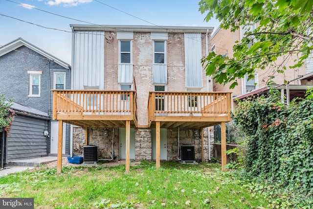 back of property featuring cooling unit, a lawn, and a deck