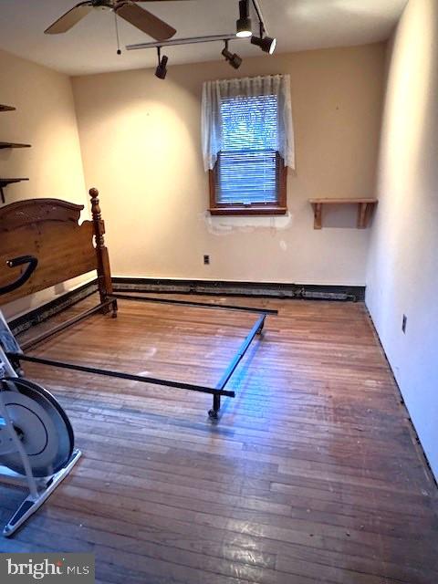 exercise area with ceiling fan and dark wood-style floors