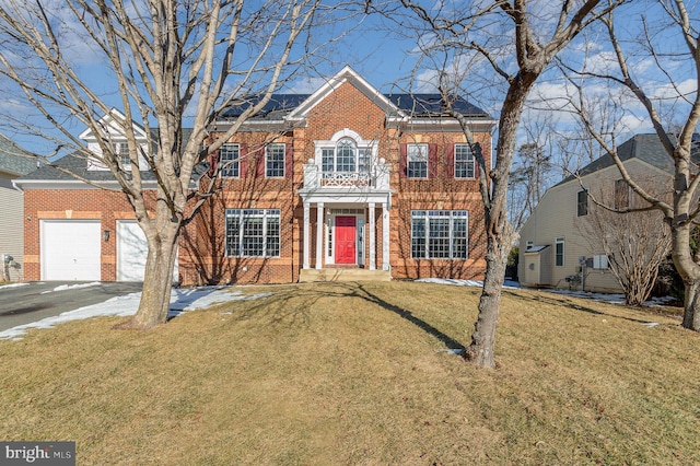 colonial-style house with a front yard and a garage