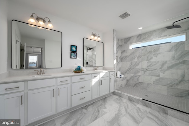 bathroom with tiled shower and vanity